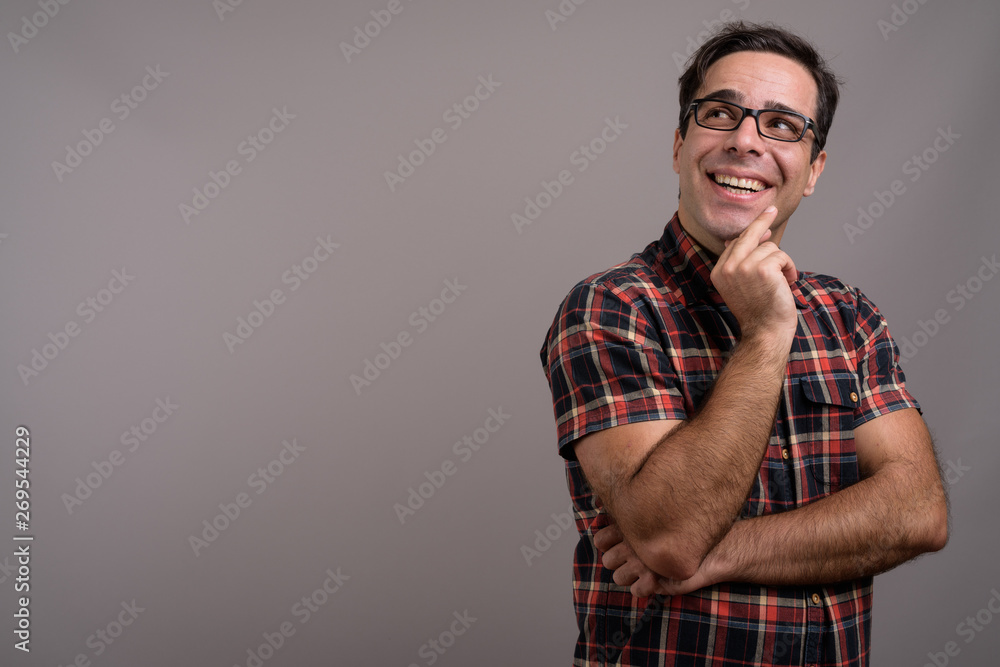 Handsome Persian man wearing eyeglasses against gray background Handsome Persian man wearing eyeglasses against gray background