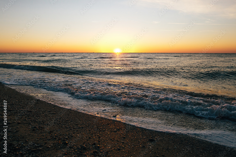 Beautiful sun rise and sea waves foam closeup at sandy beach with seashells tropical island. Waves in ocean at sunset light. Tranquil calm moment. Summer vacation. Copy space Beautiful sun rise and sea waves foam closeup at sandy beach with seashells tropical island. Waves in ocean at sunset light. Tranquil calm moment. Summer vacation. Copy space