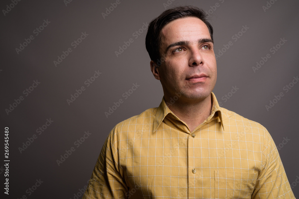 Portrait of handsome Persian man against gray background Portrait of handsome Persian man against gray background