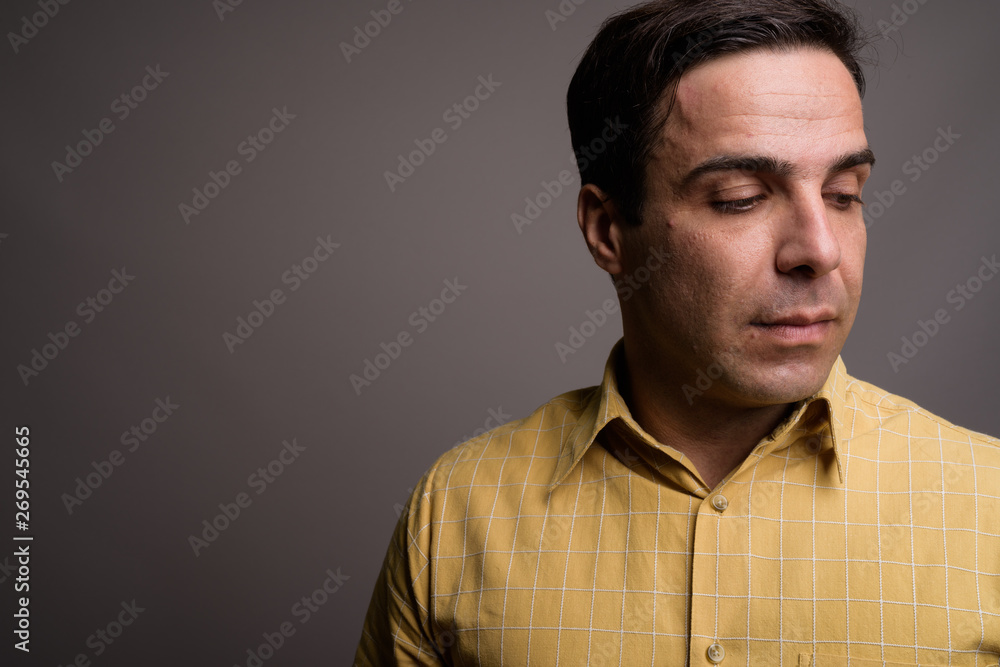 Obraz premium Portrait of handsome Persian man against gray background