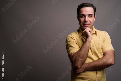 Portrait of handsome Persian man against gray background