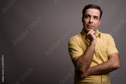 Portrait of handsome Persian man against gray background