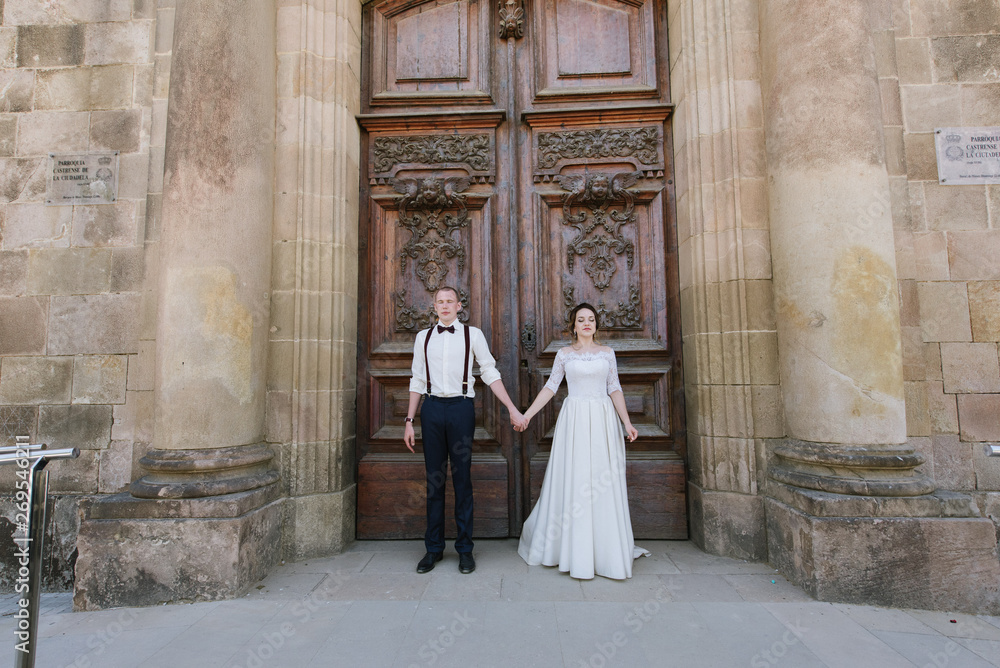 Bride and groom posing at the door of the building