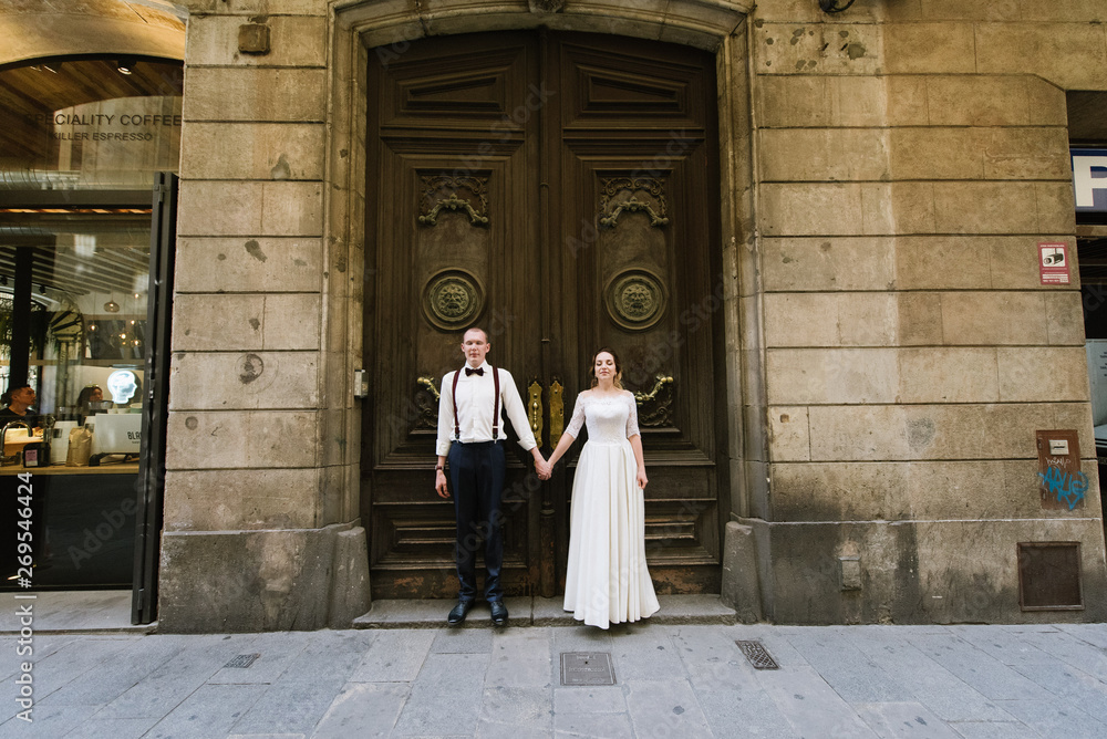 Naklejka premium Bride and groom posing on city streets