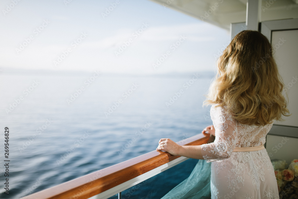 Young beautiful woman on the deck of the ship at sea.