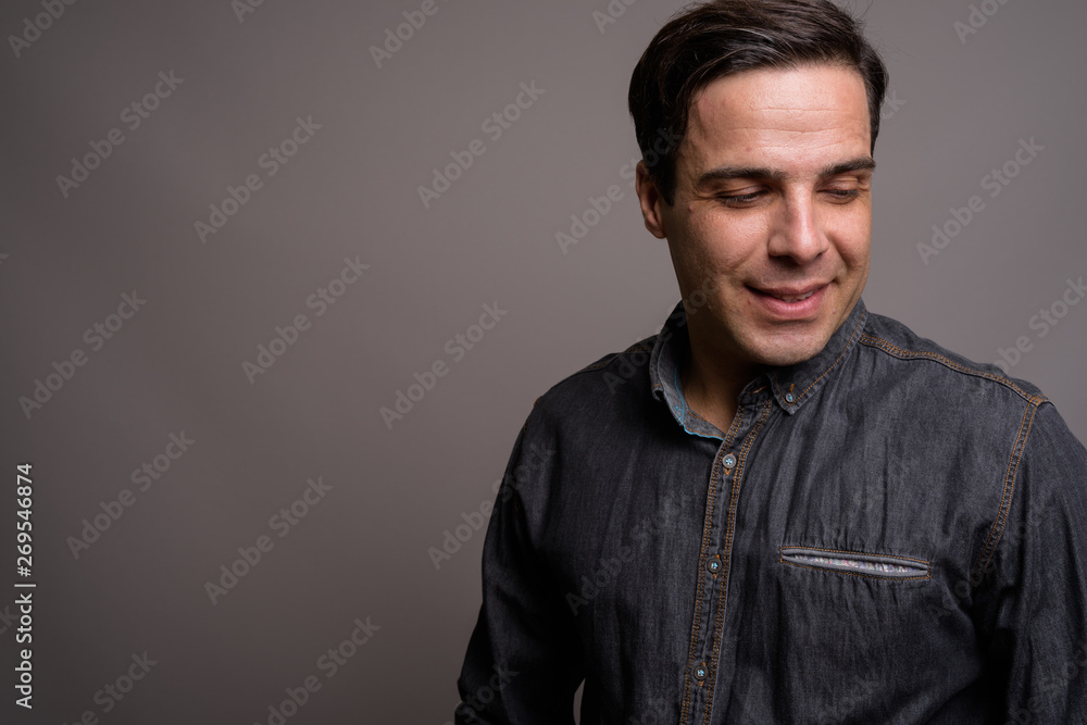 Portrait of handsome Persian man against gray background Portrait of handsome Persian man against gray background
