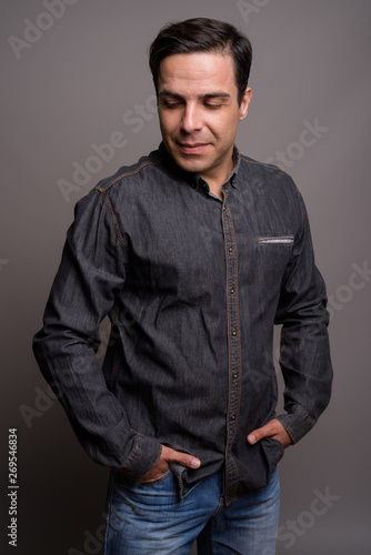 Portrait of handsome Persian man against gray background