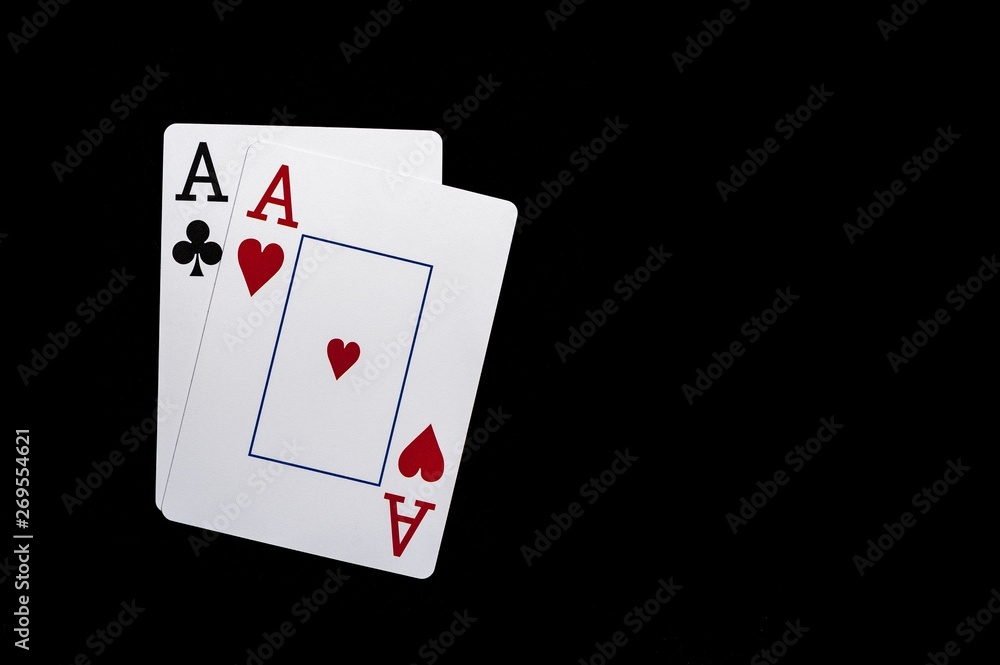 Two aces playing cards on black table