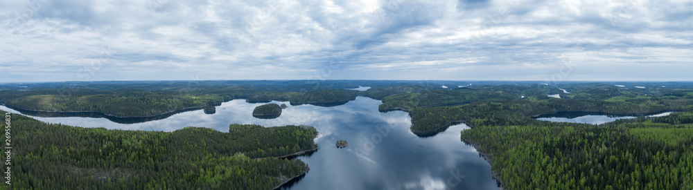 Aerial view of blue lakes and green forests on a cloudy summer day in Finland, Kolovesi National Park. 