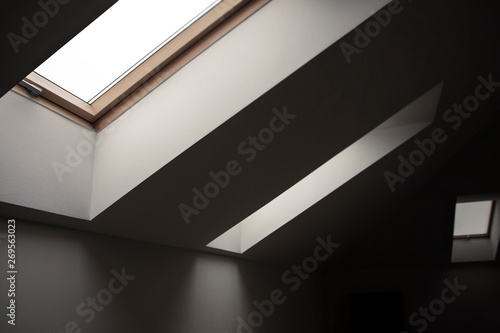 Windows in the attic. Architectural elements.Contrasting geometric interior details, white walls, ceilings, frames, empty room.
