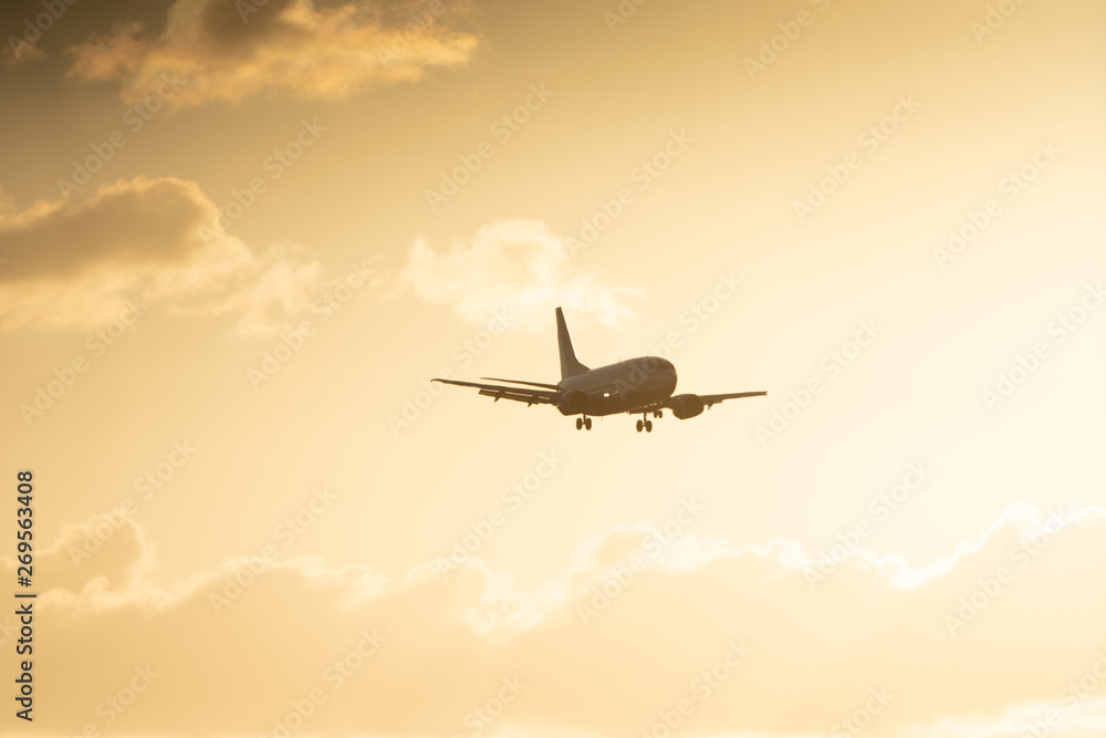 Airplane landing on a sunset sky