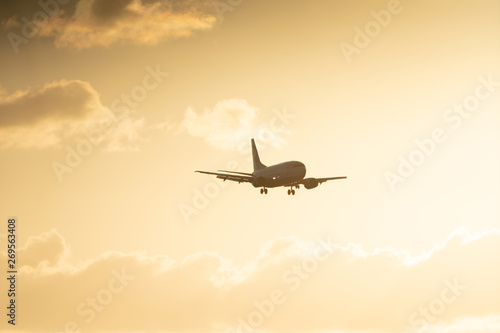 Airplane landing on a sunset sky