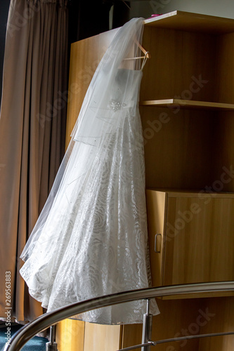 Bridal dress hanging at wooden closet