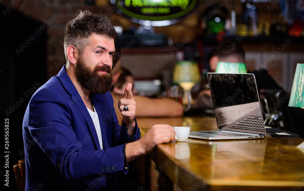 Manager work online while enjoy coffee. Hipster freelancer work online blog notebook. Surfing internet. Online job. Man bearded businessman sit pub with laptop and cup of coffee. Freelance benefit