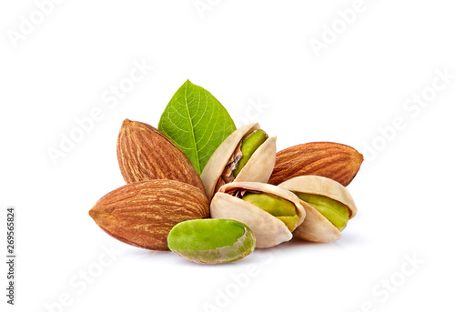 Pistachio nuts and almonds with leaves in closeup isolated