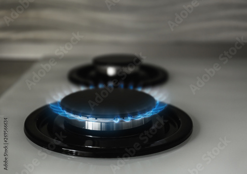 Gas burner with blue flame on modern stove, closeup © New Africa