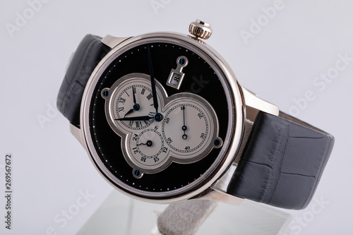 Silver wristwatch with white dial, black clockwise, stopwatch and chronograph on black leather strap on white background