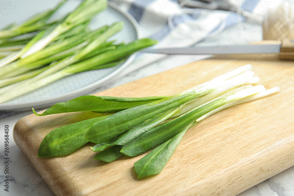 Board with wild garlic or ramson on table, closeup Board with wild garlic or ramson on table, closeup