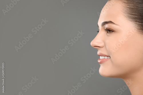 Portrait of young woman with beautiful face and natural makeup on color background, closeup. Space for text