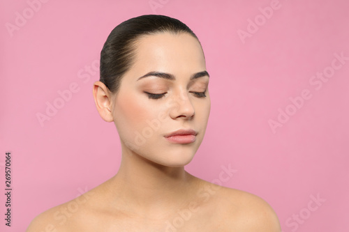 Portrait of young woman with beautiful face and natural makeup on color background