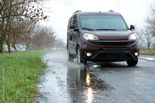 Wet suburban road with car on rainy day