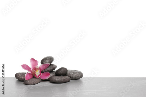 Orchid flower with spa stones on white background. Space for text