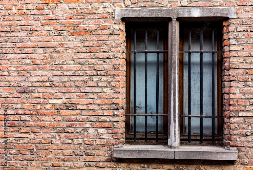 Front view red brick wall facade two rectangular windows metal protections Front view red brick wall facade two rectangular windows metal protections