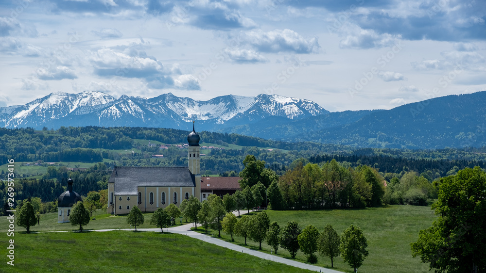 Kirche vor Alpen in Bayern, Frühling