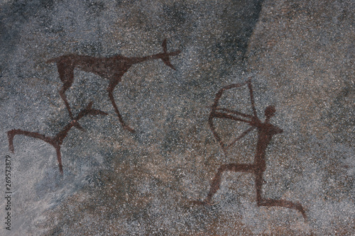 scene of ancient hunting painted on the wall of the cave. history of antiquities, archaeology.