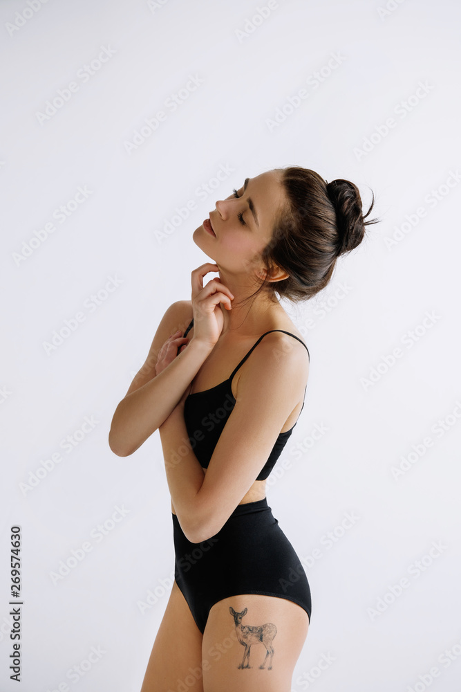 Fashion ballet. Young female ballet dancer in black bodysuit against white studio background. Caucasian ballerina like a fashion model. Style, contemporary choreography concept. Creative art photo. Fashion ballet. Young female ballet dancer in black bodysuit against white studio background. Caucasian ballerina like a fashion model. Style, contemporary choreography concept. Creative art photo.