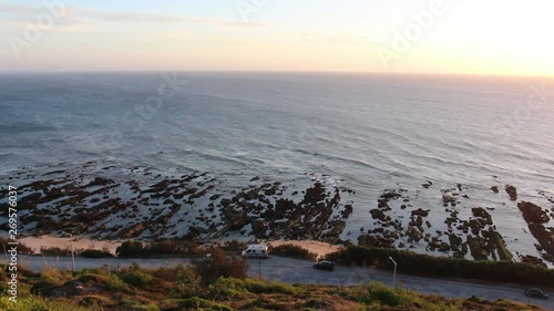 Gentle Ocean waves on rocky shore during a foggy day, seen from a viewpoint in Cabo Mondego, in Portugal.