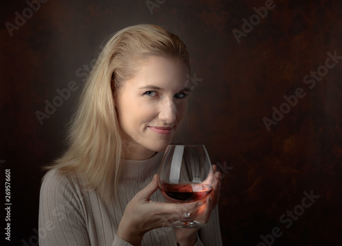 Portrait of a beautiful woman with glass of brandy.