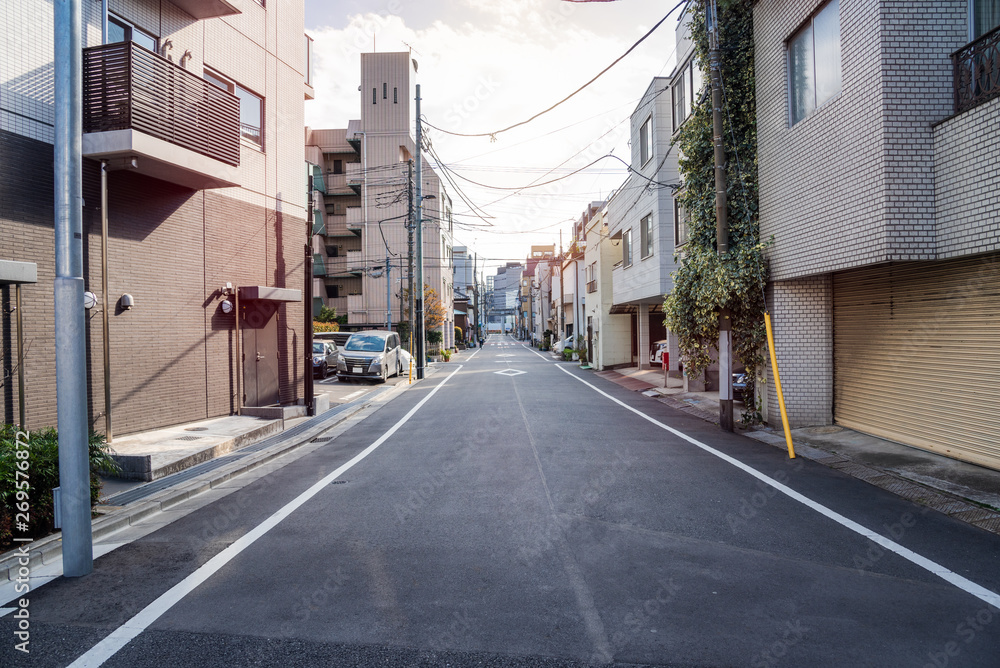 Narrow Street through residential buildings in central Tokyo on a partly cloudy early spring day