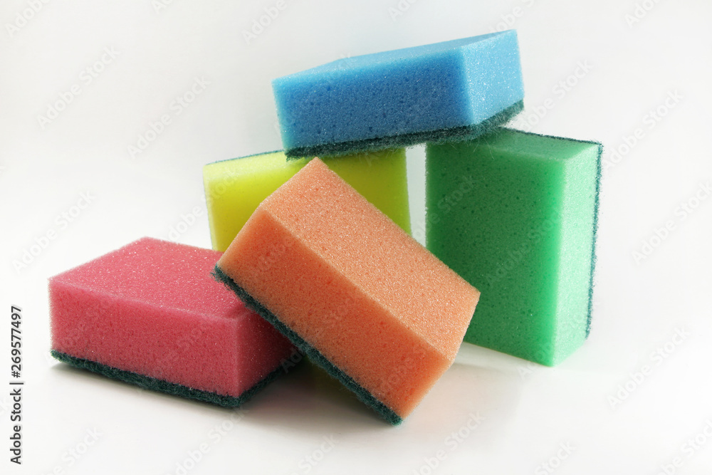 Foam sponges of different colors on a white background. Devices for washing dishes and cleaning the house. Foam sponges of different colors on a white background. Devices for washing dishes and cleaning the house.