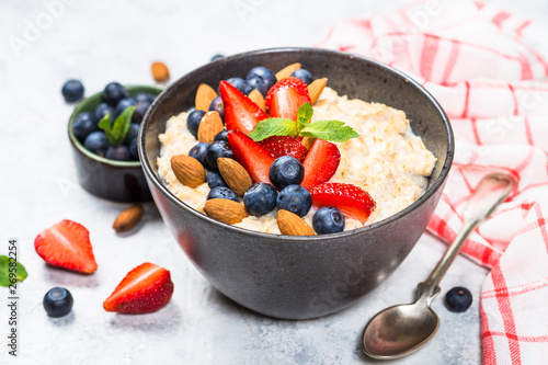 Oatmeal porridge with fresh berries and nuts. 