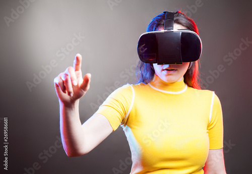 Young girl with VR goggles on head. © dragonstock