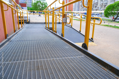 A button to call for help. A ramp for the disabled. The specific path of the ramp with stainless steel handrail. Sign for disabled. photo