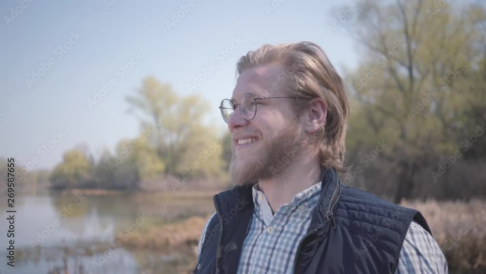 Bearded man looking at amazing view of river and forest Bearded man looking at amazing view of river and forest