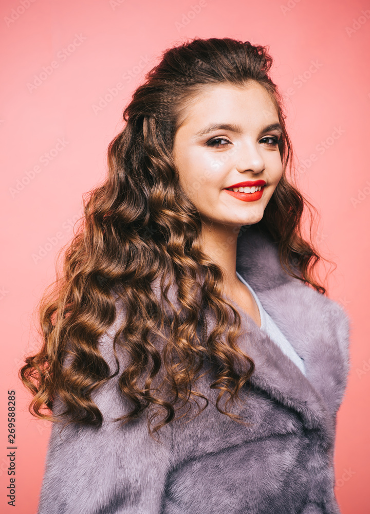 Boosting heavy curls volume. Teenage girl with stylish wavy hairstyle.  Young woman with long locks of hair. Pretty girl with curly hairstyle.  Healthy hair care habits. Hair styling in beauty salon Stock