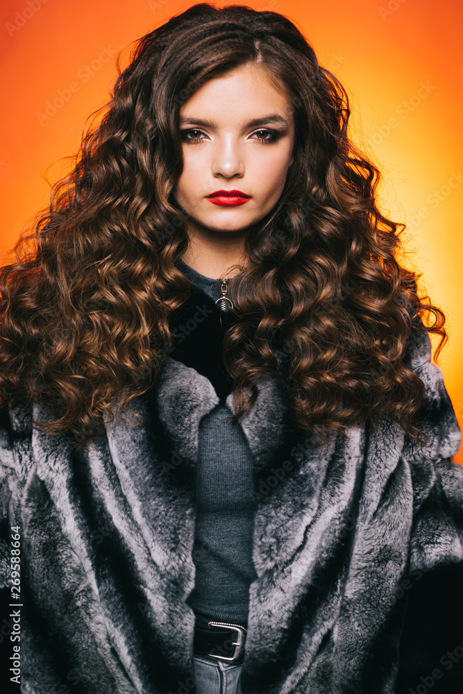Shaping curly hair. Young woman with long locks of hair. Pretty girl with  curly hairstyle. Teenage girl with stylish wavy hairstyle. Healthy hair  care habits. Hair styling in beauty salon Stock Photo |
