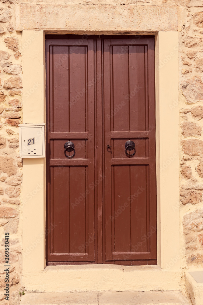 The background old beige stony wall with retro door The background old beige stony wall with retro door