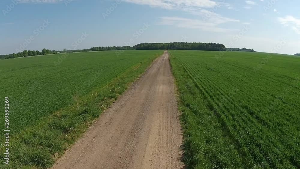Fast Flying Backward Over Gravel Road And Green Agriculture Fields. Aerial Footage. Fast Flying Backward Over Gravel Road And Green Agriculture Fields. Aerial Footage.