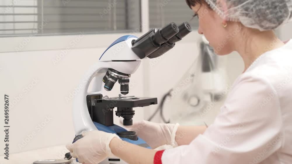 Scientist researcher using microscope in a laboratory. Examining human biological samples. Medical research concept Scientist researcher using microscope in a laboratory. Examining human biological samples. Medical research concept