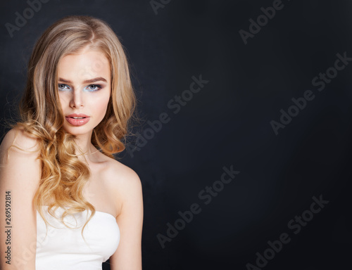 Beautiful blonde woman portrait. Pretty girl with blonde hair on black background