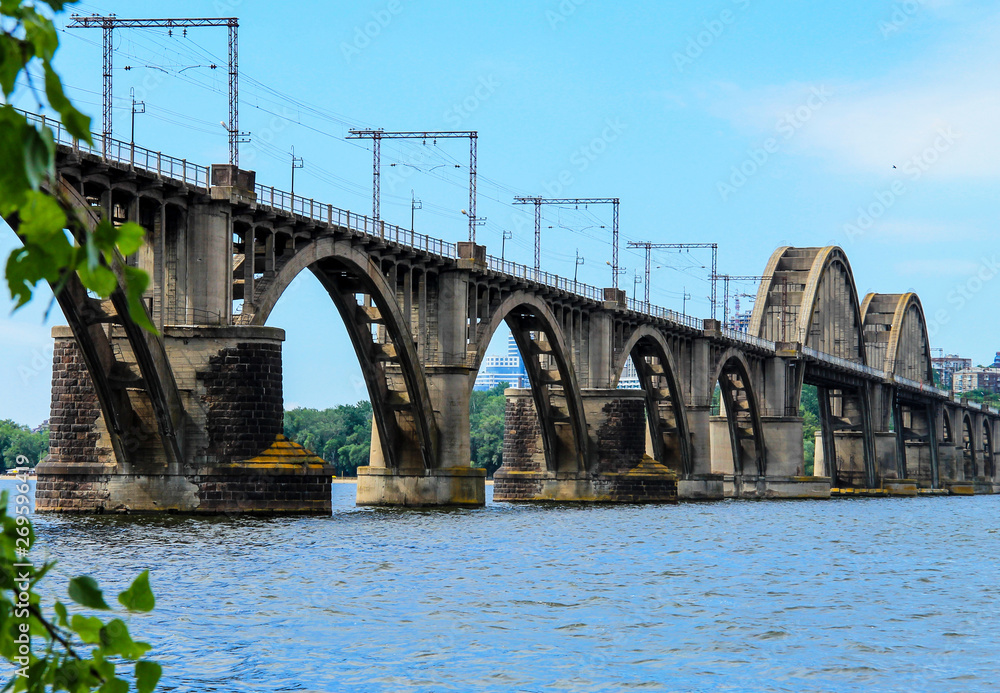 Beautiful landscape of the Ukrainian  Dnipro city with old arch railway Merefo-Kherson bridge across the Dnieper river in Dnepropetrovsk, Ukraine. Bridge in spring and summer