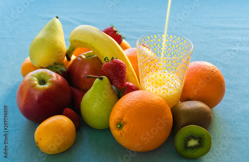 Colorful Fresh Fruits And Juice on blue sky background.