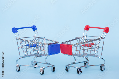 Empty grocery carts on wheels on a blue background