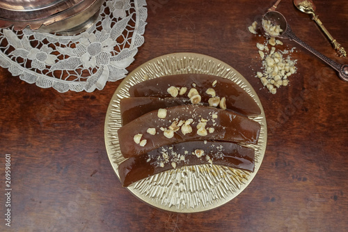 Traditional Turkish pumpkin dessert with nuts on wooden background