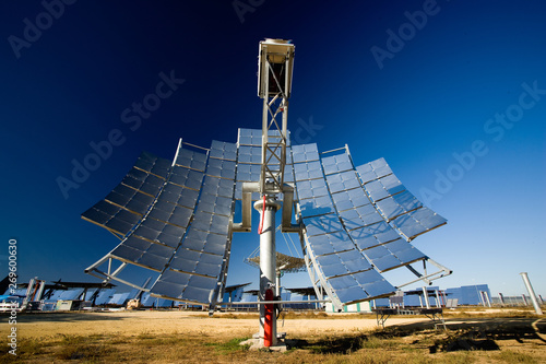 Modern solar panel installed in middle of photovoltaic power station against cloudless blue sky on sunny day in countryside photo