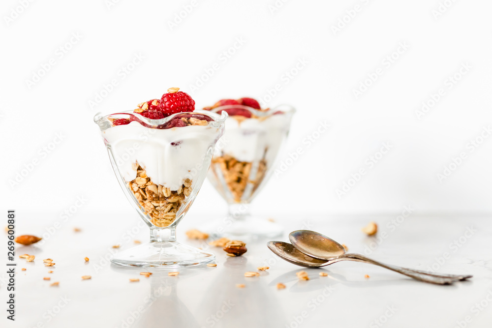 Fresh Raspberries on Top of Granola and Yogurt Parfait On Light Background, Space For Text Fresh Raspberries on Top of Granola and Yogurt Parfait On Light Background, Space For Text